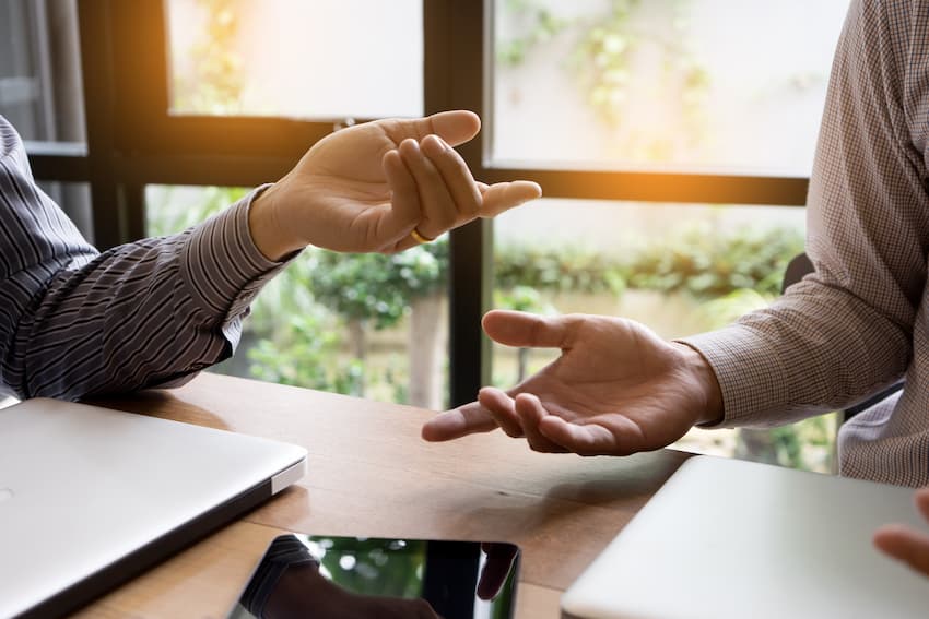 Discussion entre collègues autour d’une table illustrant le dialogue social et la prévention en entreprise.